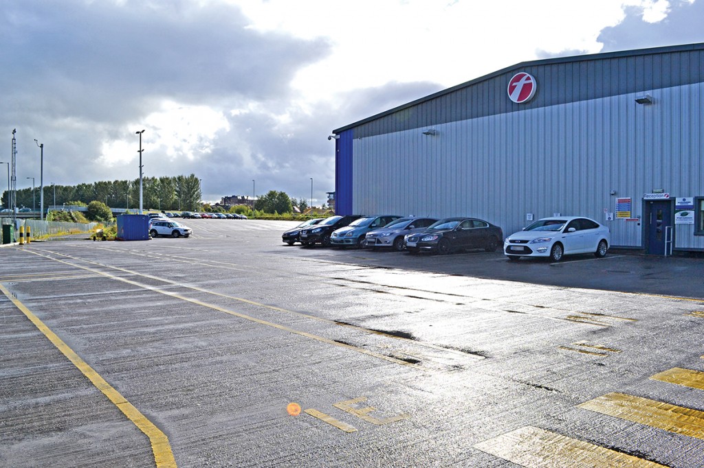 This carpark is full of buses at night.