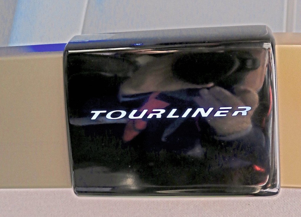 Illuminated Tourliner signs are featured at intervals along the luggage rack edges
