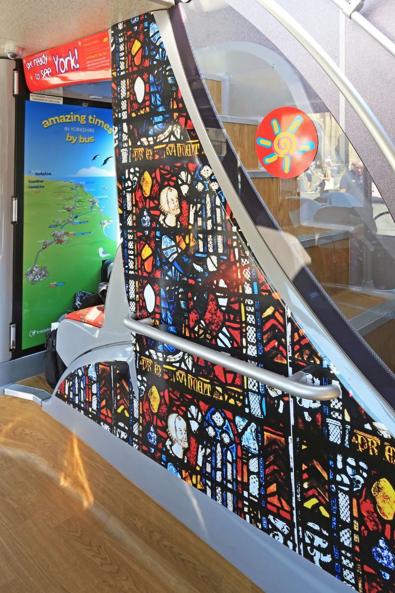 The staircase panel is decorated with a large motif of York Minster’s stained-glass windows. The back wall of the cab advertises Coastliner, another Transdev product from York