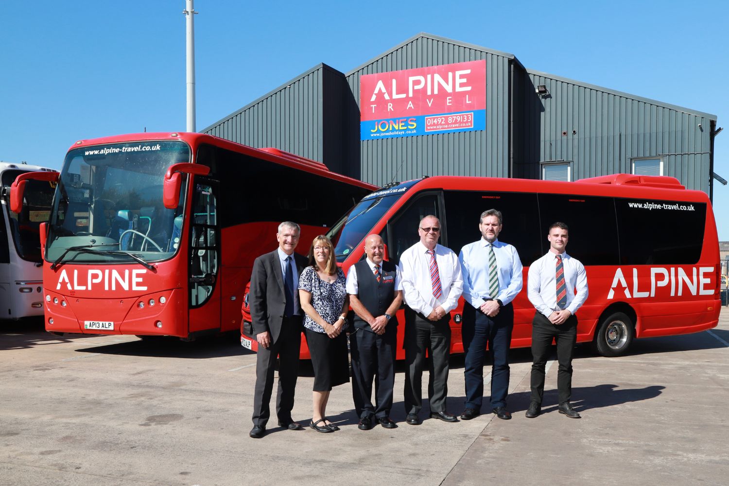 Chris and Sally Owens (left) with Mike Woodyat (in house trained tour driver), Mike Spotswood (Compliance Manager) Terrance Jones (Head of Operations) and Daniel Cuthbert (Llandudno Depot Manager) in front of Alpine Travel’s latest Noone minicoach and the Llandudno depot building