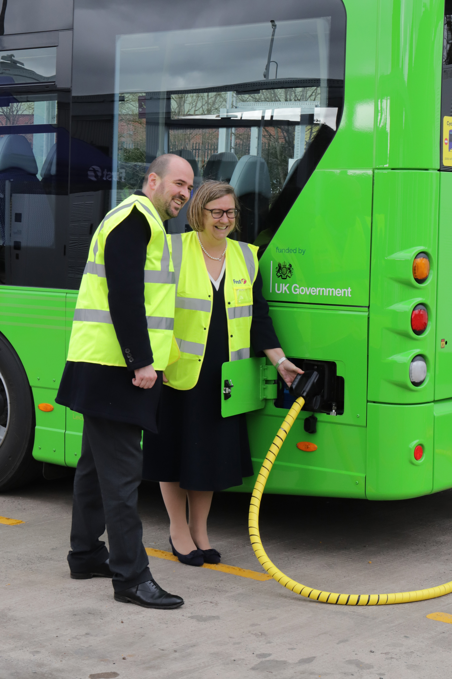 Transport Minister, Richard Holden MP joins First Bus MD Janette Bell in demonstrating the plug-in charging process for the Wrightbus GB Kite Electroliner